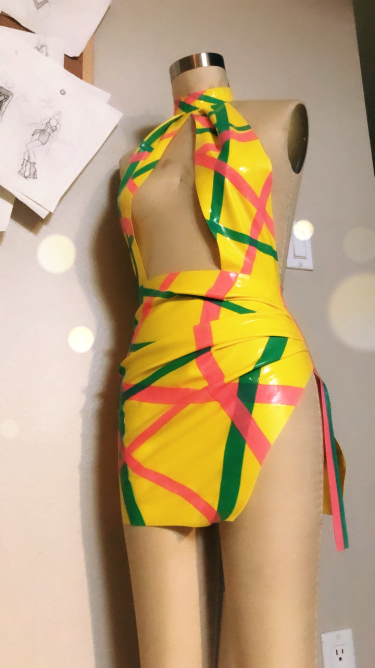 Colorful latex dress with geometric pattern on a mannequin against a neutral background