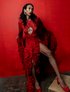 Woman in a red dress with ruffled details against a red background
